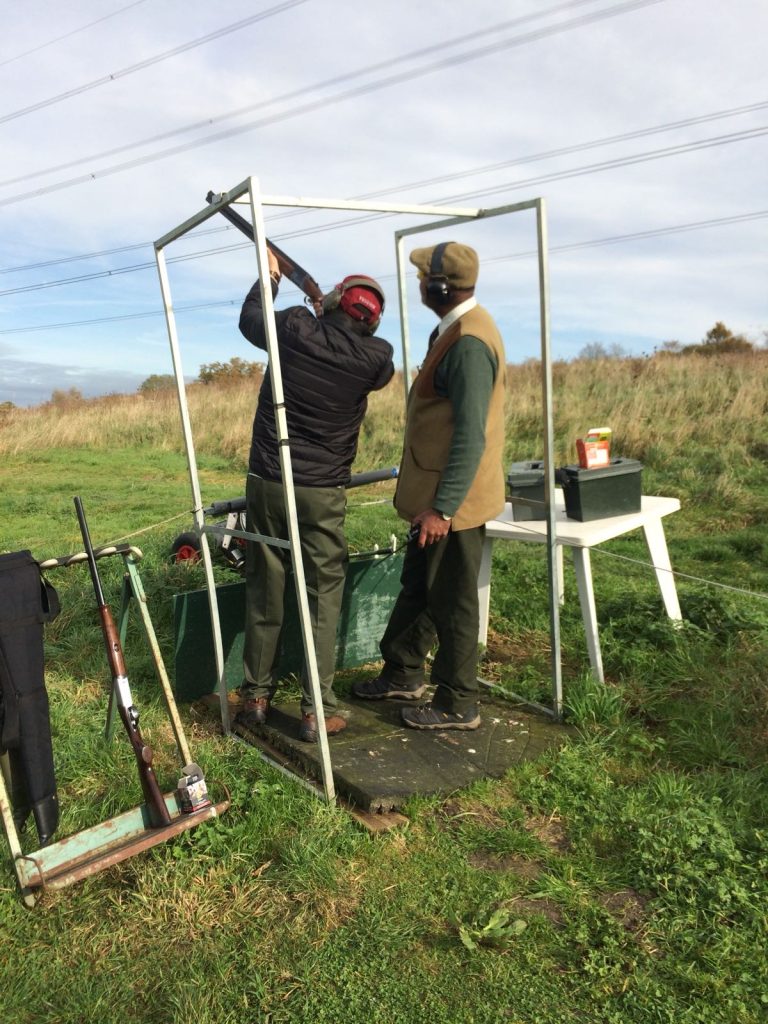 Instructor and shooter with cartridge box at a UK shooting stand